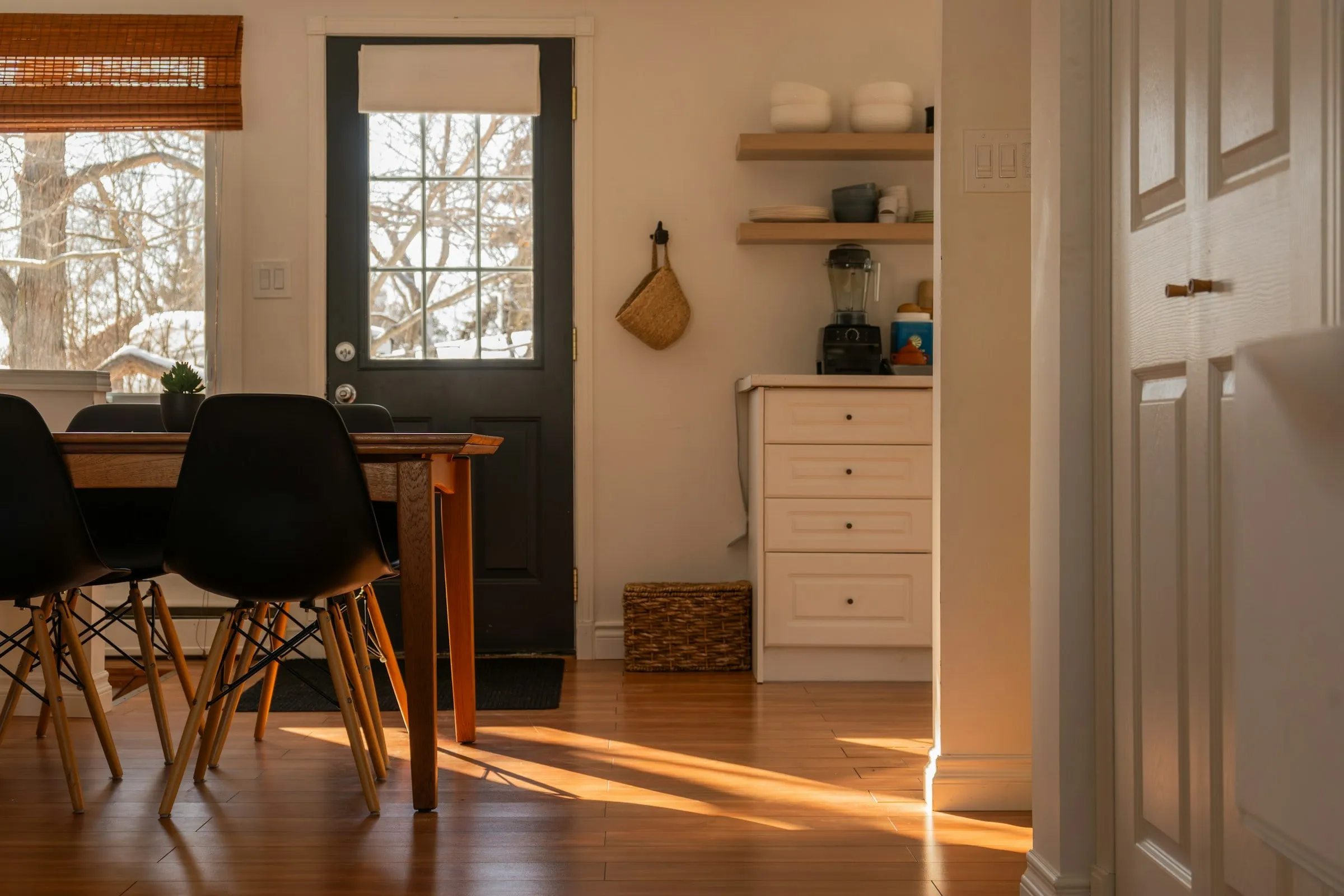 Low winter sun across the floor of a lived-in kitchen and dining room